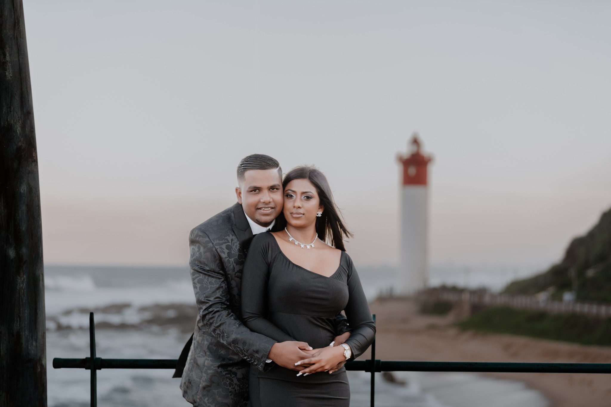  couple on beach in front of lighthouse 