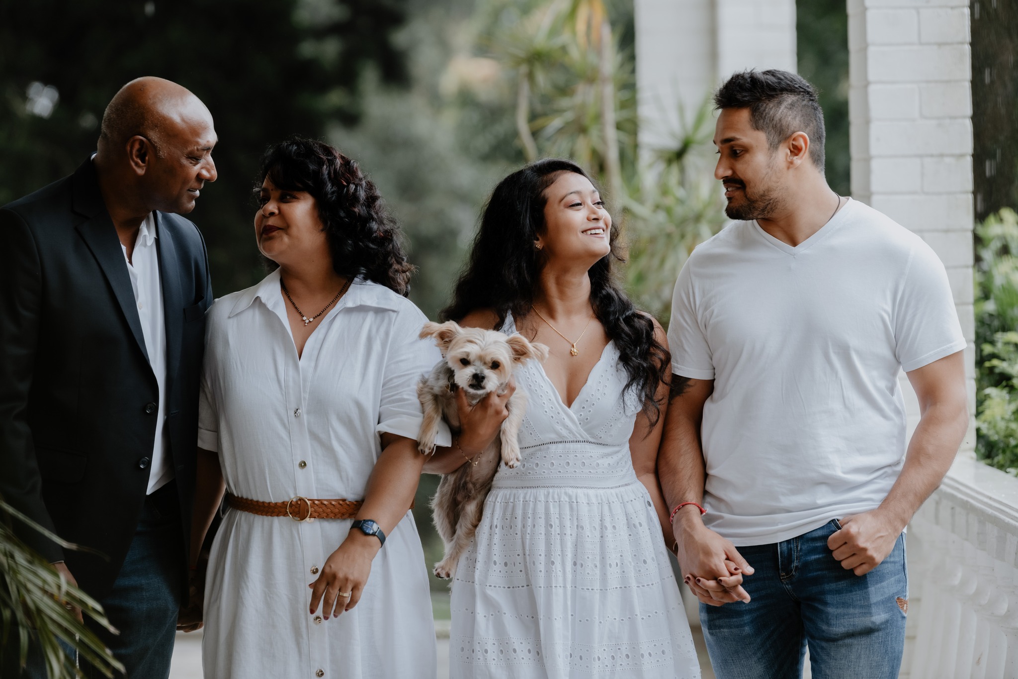 family walking while holding dog 