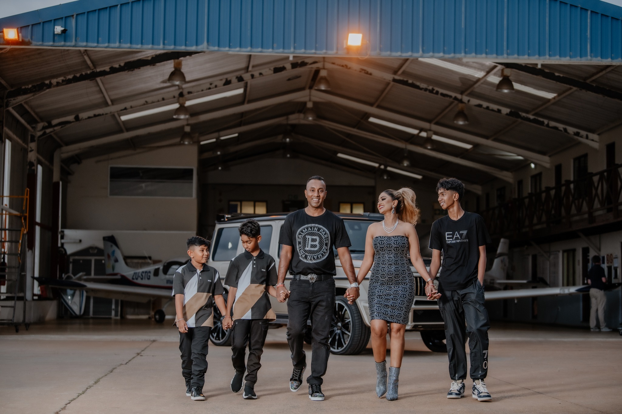  family laughing and walking in front of hanger 