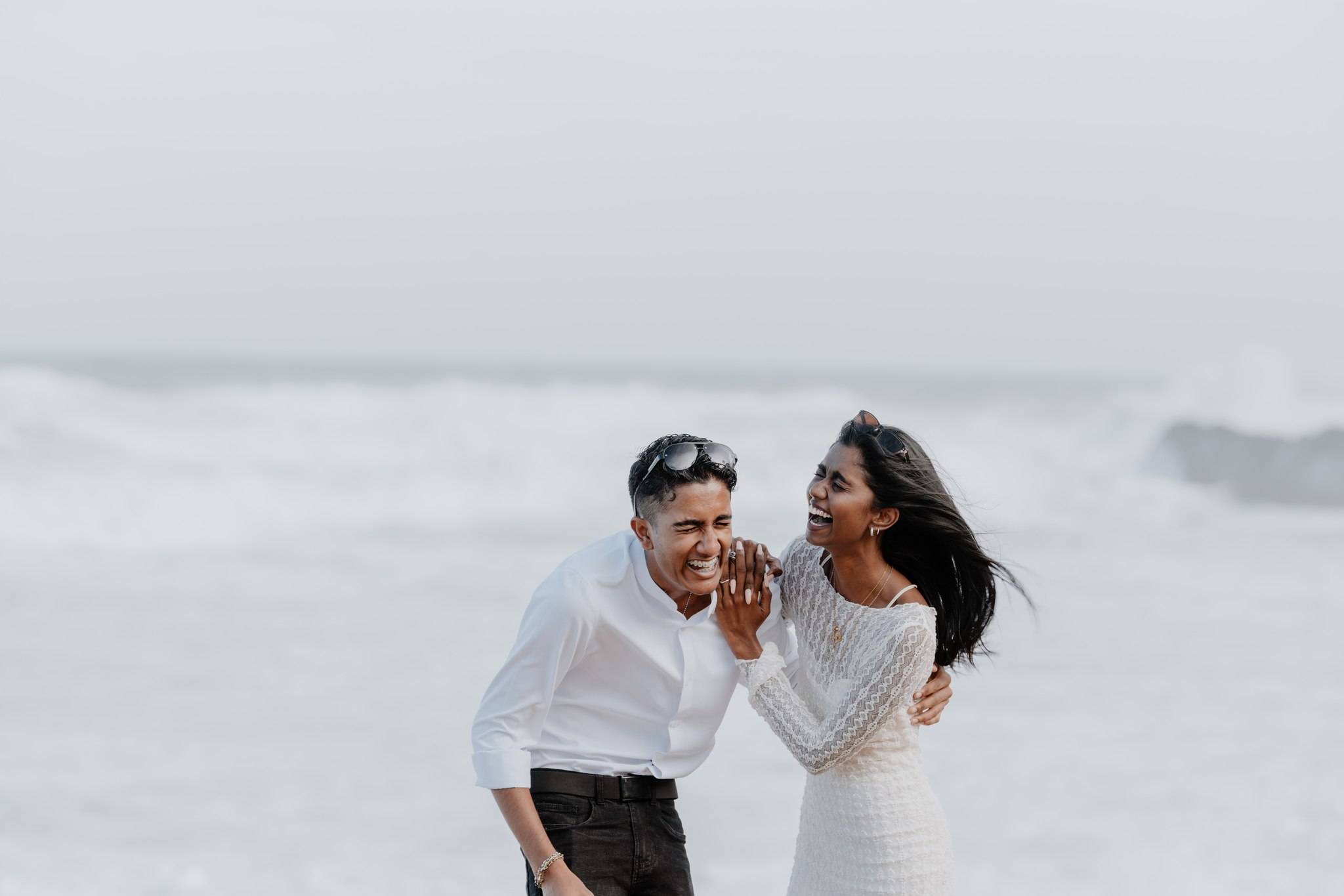  man and woman laughing on beach 