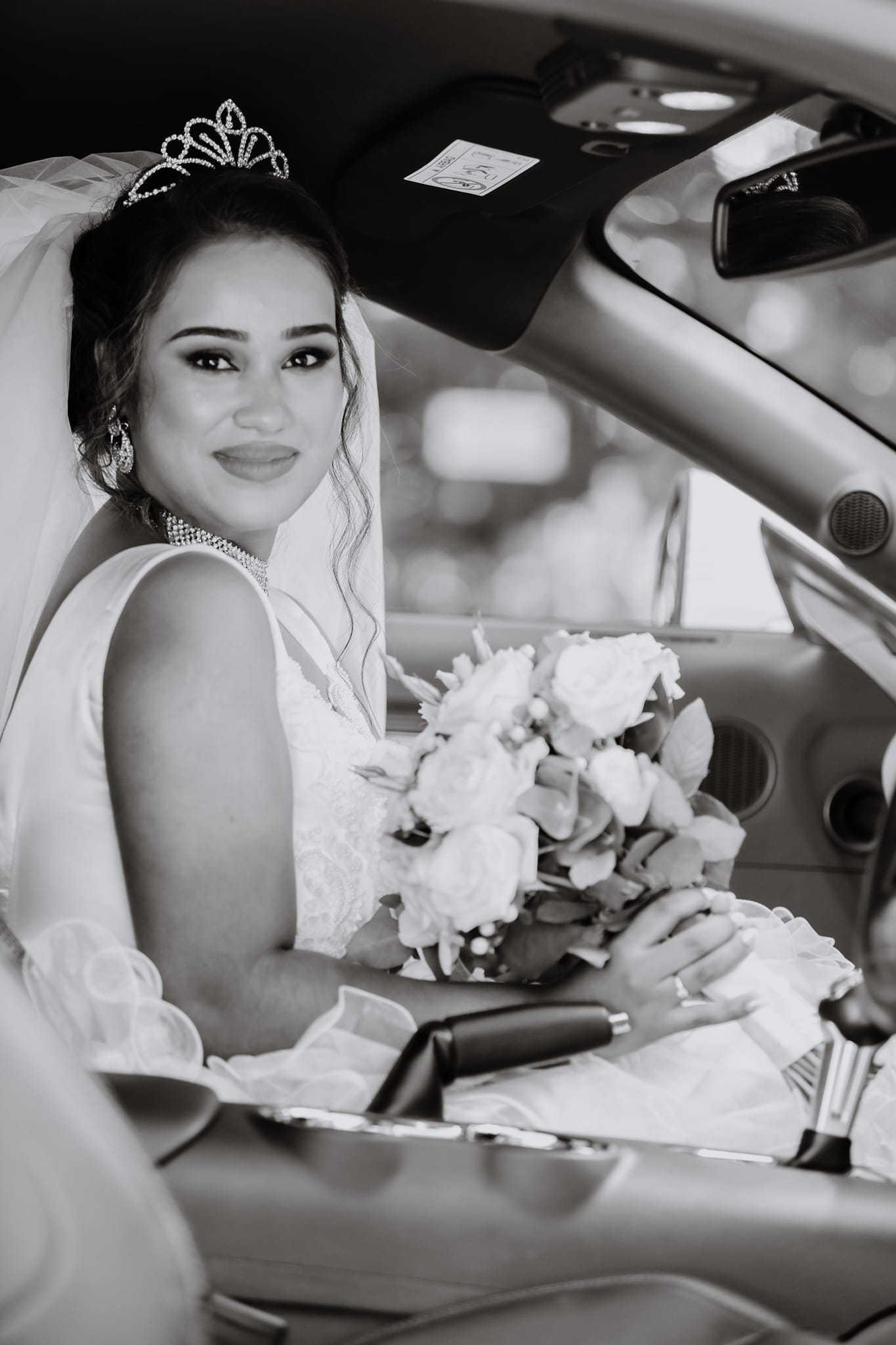  bride holding flowers in car 