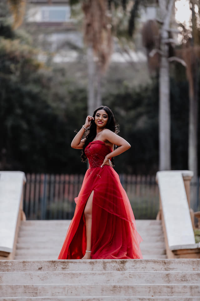  woman posing in red dress on stairs 