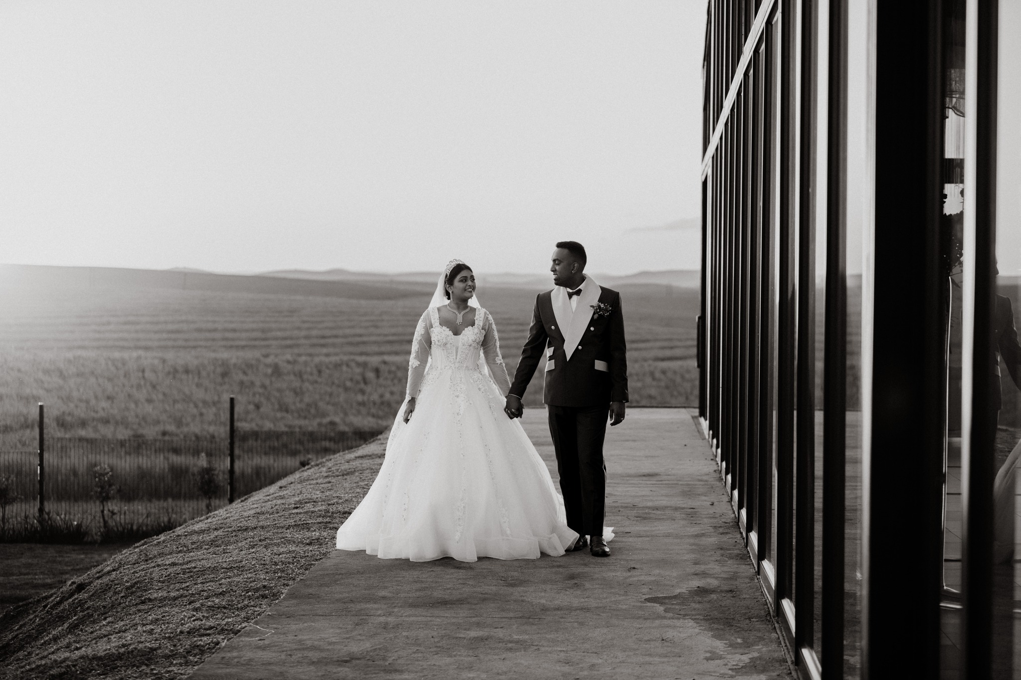  black and white photo of newly weds walking 